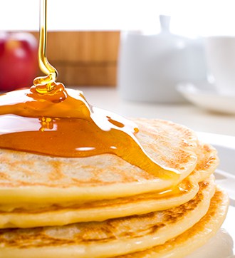 pancakes with maple creme syrup being pour on them