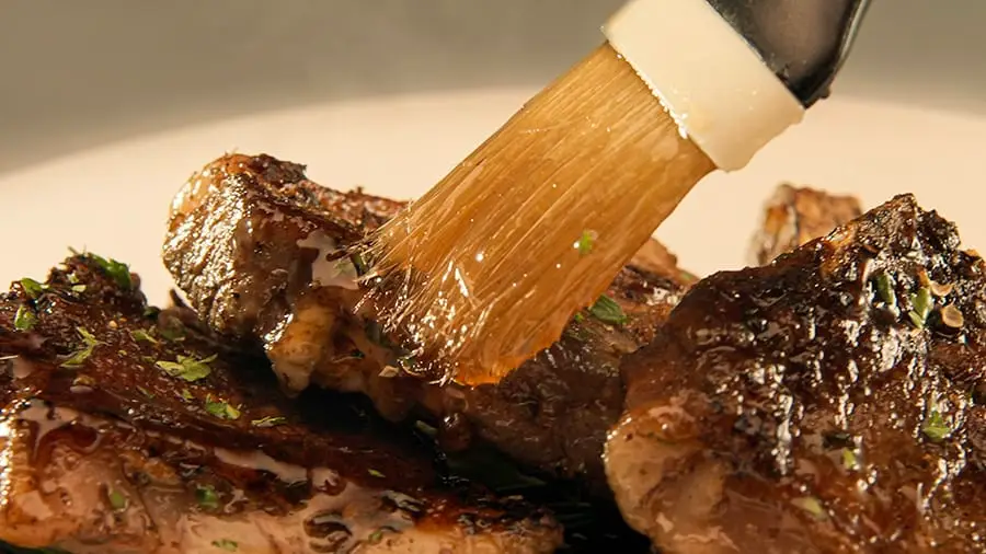Grilled steak bites brushed with honey creme syrup, glossy and caramelized on a plate.